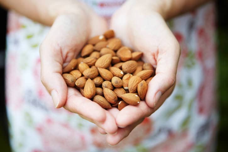 Woman Holding Handful Of Almonds