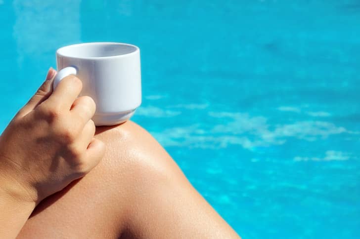 Closeup image of real attractive female beauty holding cup of coffee