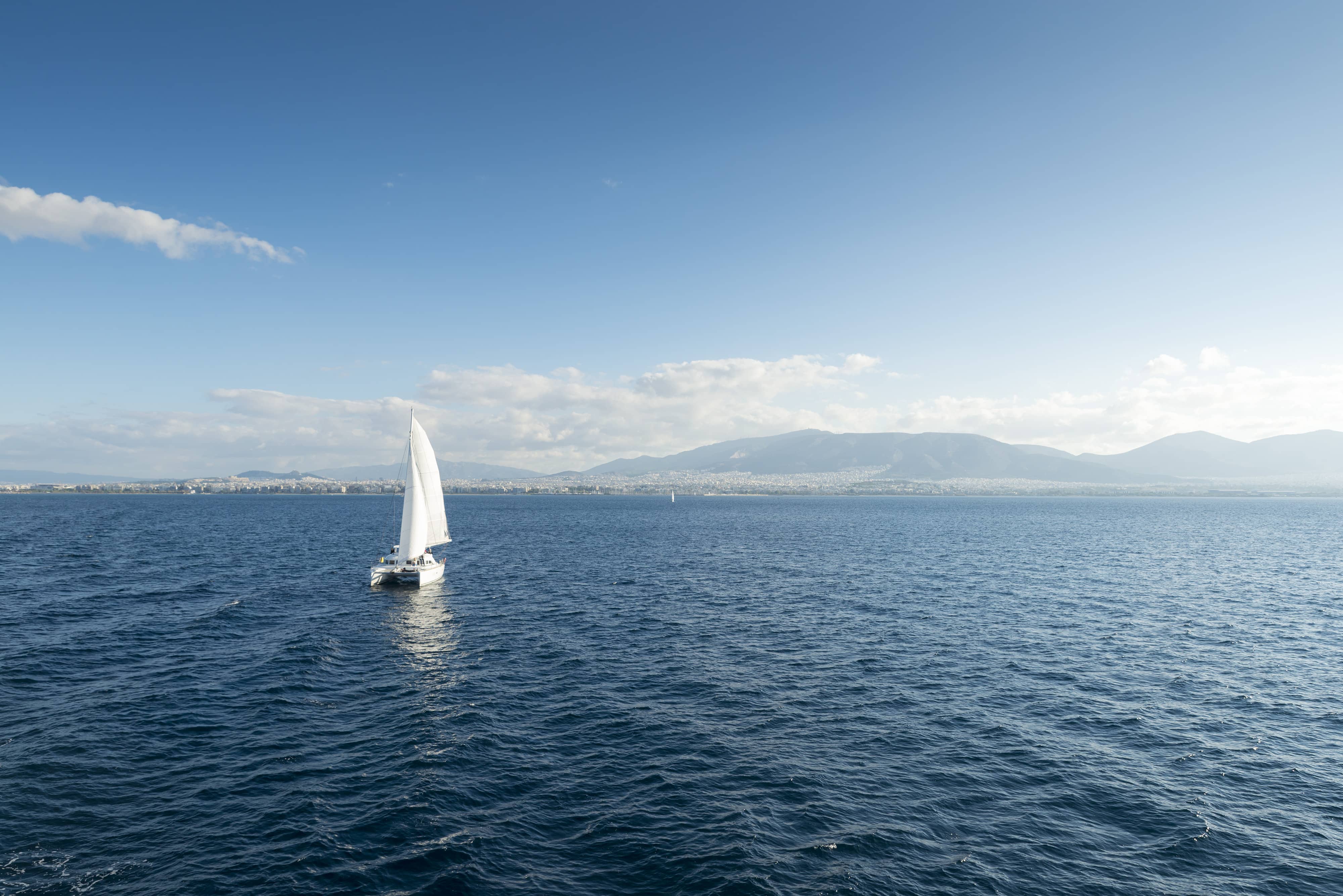 sailboat sailing ship in the Aegean sea. In the background the city of Athens is